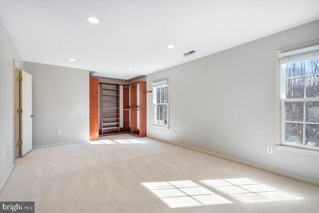 unfurnished bedroom featuring recessed lighting, visible vents, light carpet, and baseboards