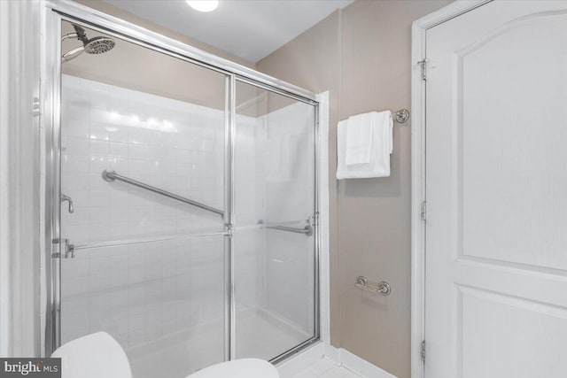 bathroom featuring a stall shower and toilet