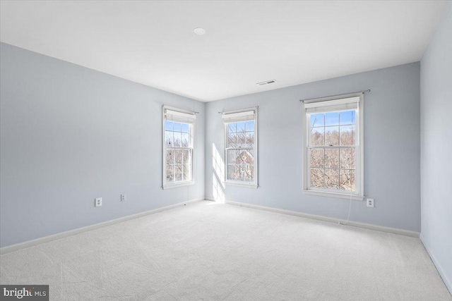 carpeted spare room with baseboards and visible vents