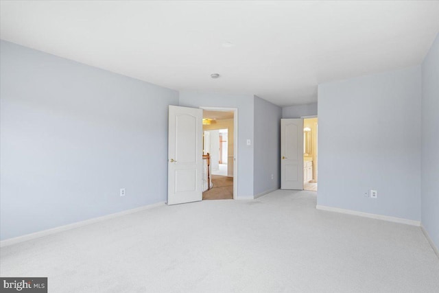 unfurnished bedroom featuring light carpet and baseboards