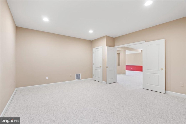 spare room featuring light carpet, recessed lighting, visible vents, and baseboards