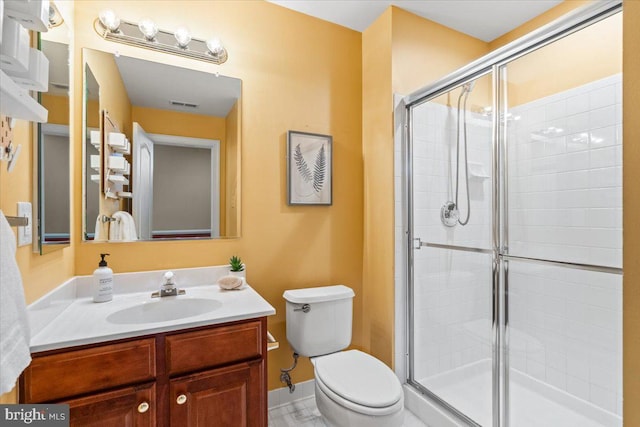 bathroom featuring visible vents, vanity, a shower stall, and toilet