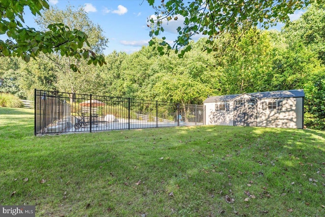 view of yard featuring an outbuilding, fence, and a shed