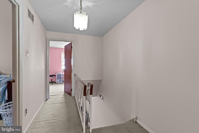 corridor with baseboards, visible vents, carpet flooring, and an upstairs landing