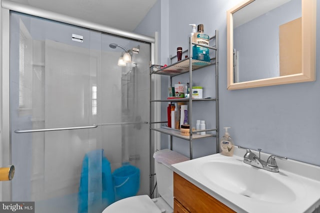 full bath with a stall shower, vanity, and toilet