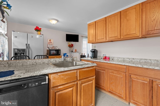 kitchen with black dishwasher, light stone countertops, stainless steel refrigerator with ice dispenser, a sink, and light tile patterned flooring