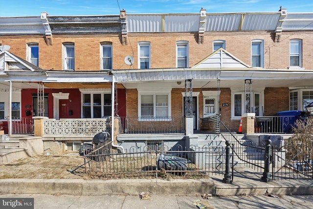 townhome / multi-family property featuring brick siding and a fenced front yard