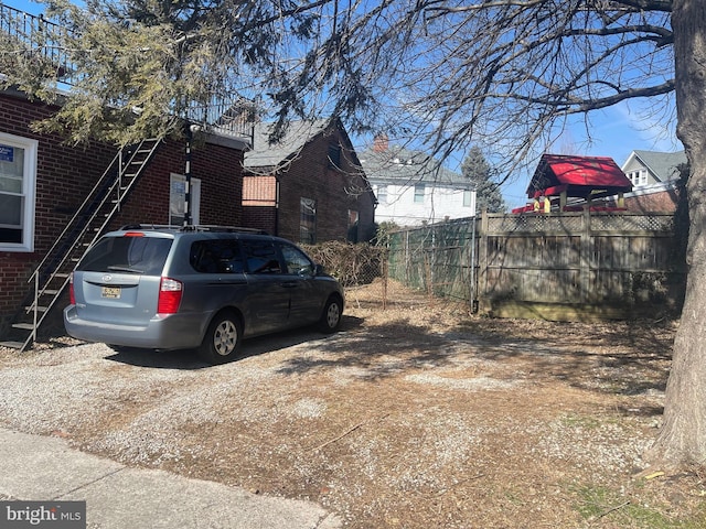 view of side of property with brick siding and fence