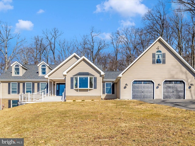 view of front of house with a garage, driveway, a shingled roof, and a front lawn