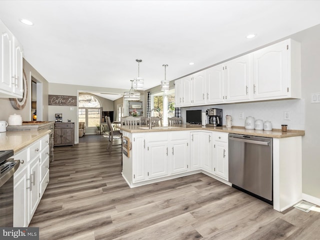 kitchen with a sink, plenty of natural light, a peninsula, and stainless steel dishwasher