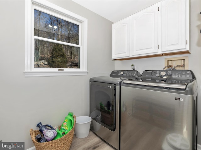 laundry room with cabinet space, independent washer and dryer, and wood finished floors