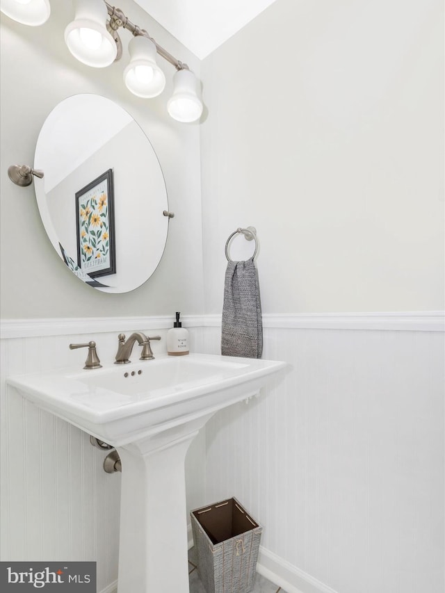 bathroom with wainscoting and a sink