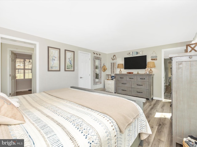 bedroom with baseboards and wood finished floors