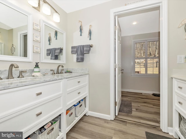 bathroom with vanity, baseboards, and wood finished floors