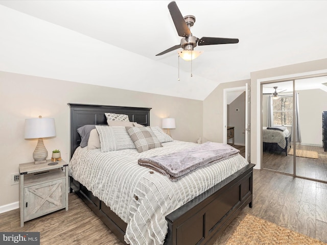 bedroom with a ceiling fan, lofted ceiling, baseboards, and wood finished floors