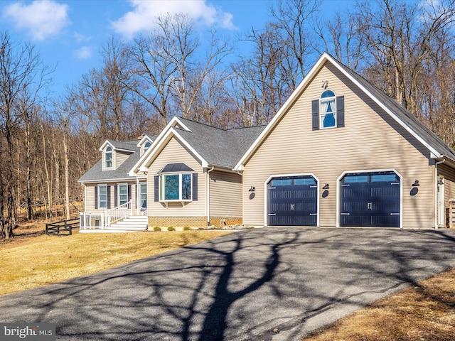 view of front facade featuring an attached garage, roof with shingles, driveway, and a front lawn