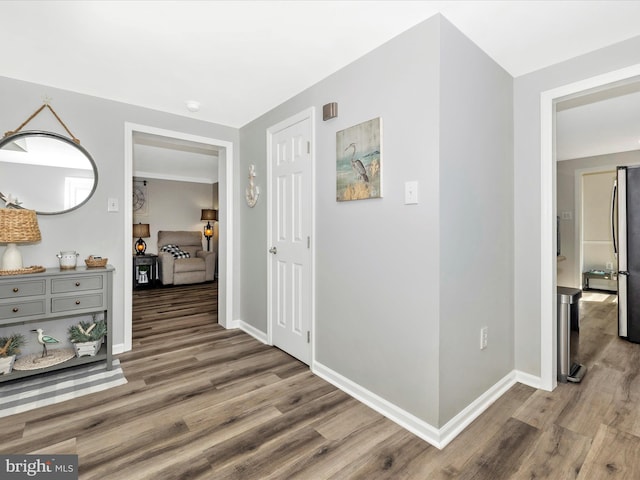 hall featuring wood finished floors and baseboards