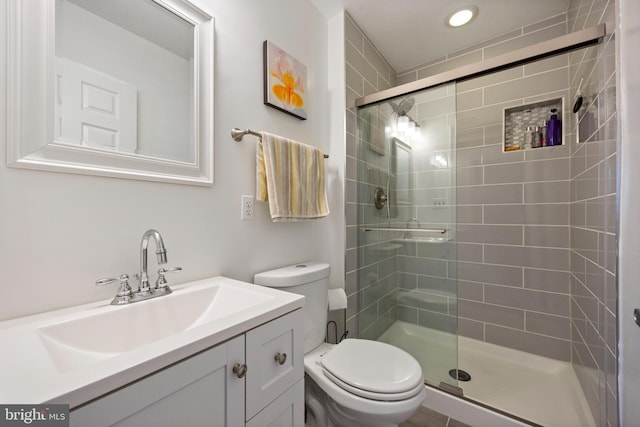 full bathroom featuring toilet, a stall shower, and vanity