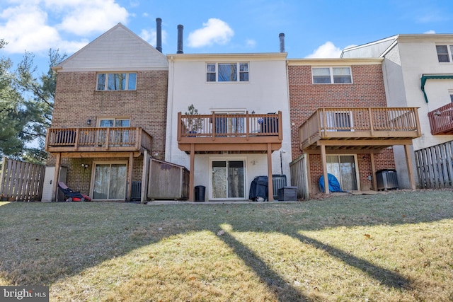 rear view of house featuring a yard, brick siding, and central air condition unit