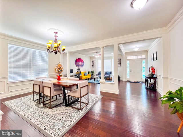 dining room with ornamental molding, dark wood finished floors, decorative columns, and a decorative wall