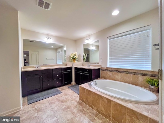 bathroom with a sink, visible vents, two vanities, and a bath