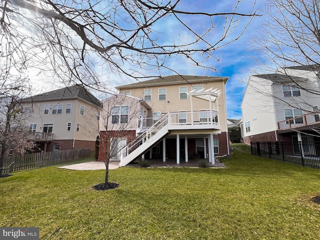 back of property with a lawn, stairs, fence, a deck, and a patio area