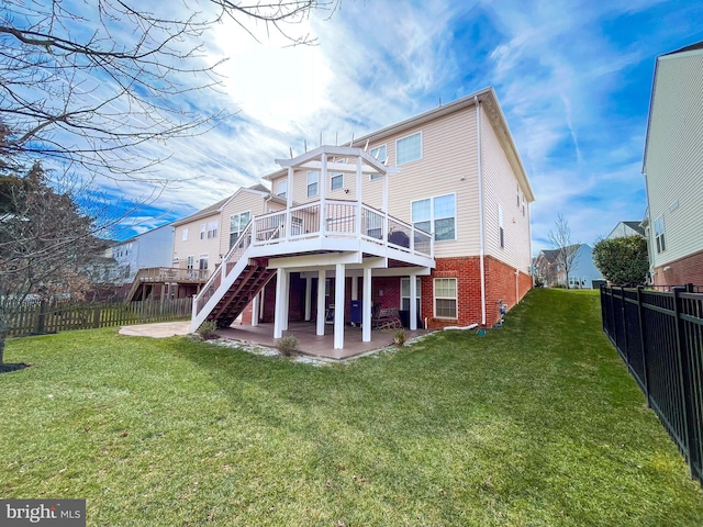 rear view of house featuring a patio, a fenced backyard, brick siding, stairs, and a yard