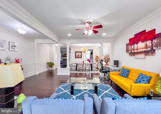 living room featuring dark wood-style flooring, crown molding, decorative columns, a decorative wall, and ceiling fan with notable chandelier