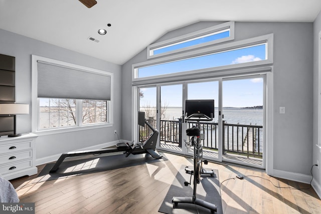 workout room with visible vents, baseboards, vaulted ceiling, and wood finished floors