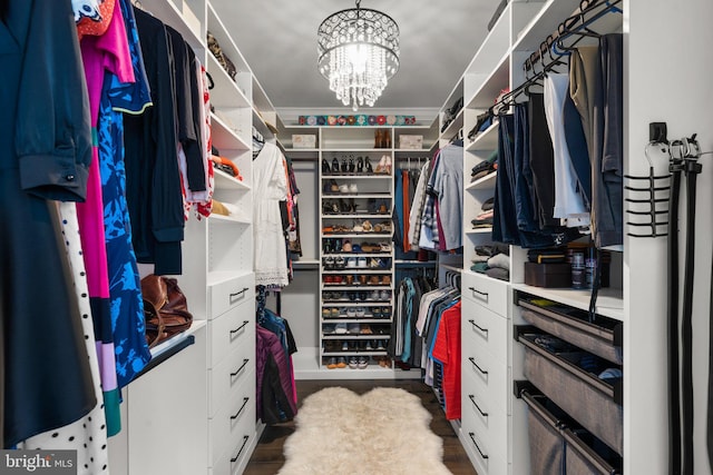 spacious closet featuring an inviting chandelier