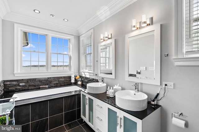 bathroom featuring a healthy amount of sunlight, crown molding, and a sink