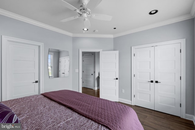 bedroom with dark wood-style floors, baseboards, ornamental molding, and a closet