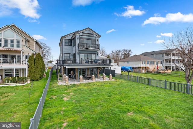 rear view of house featuring a patio area, a fenced backyard, a lawn, and a balcony