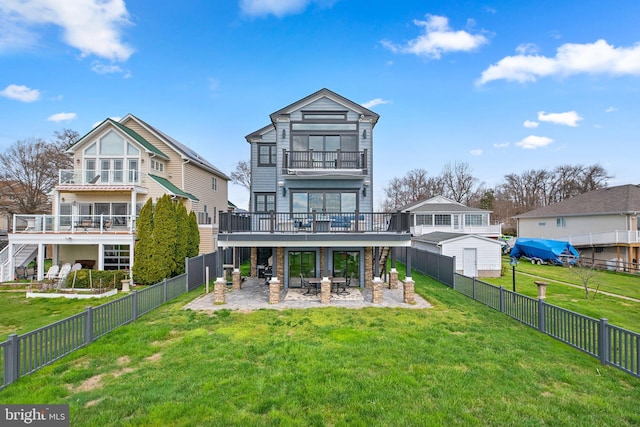 rear view of property featuring a patio, a yard, a fenced backyard, and a balcony