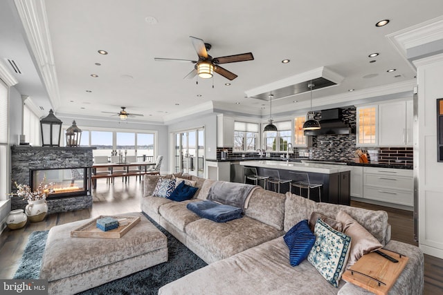 living area featuring recessed lighting, dark wood-style flooring, visible vents, and crown molding