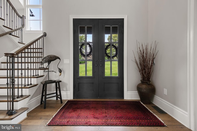 foyer with french doors, wood finished floors, visible vents, and a healthy amount of sunlight