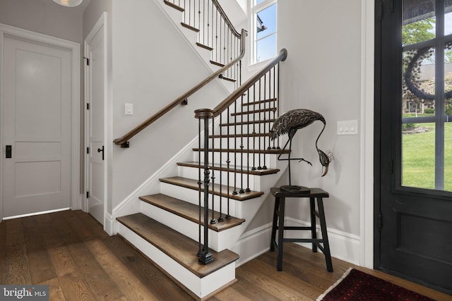 staircase with baseboards and wood finished floors