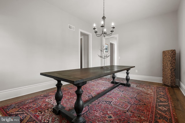 office featuring visible vents, dark wood finished floors, a notable chandelier, and baseboards