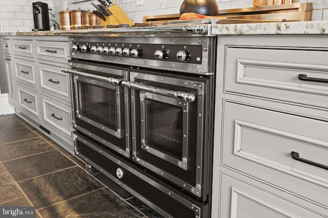 interior details with white cabinets and range with two ovens