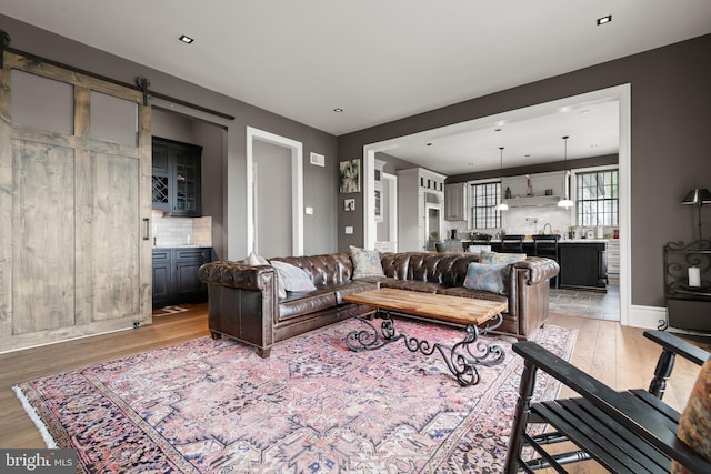 living area with light wood finished floors and a barn door