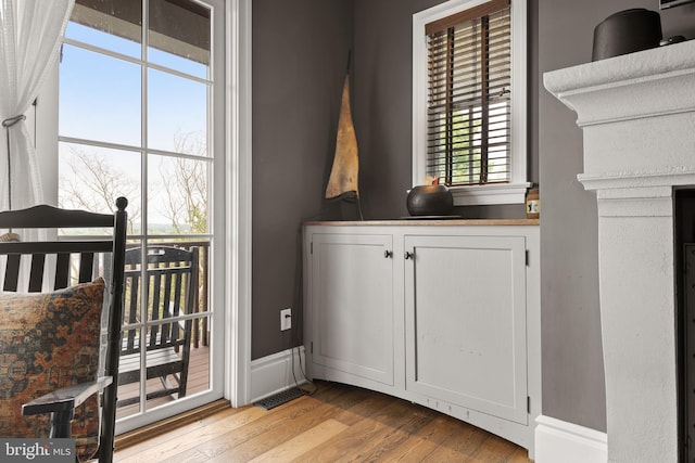 interior space with light wood-type flooring, visible vents, and baseboards