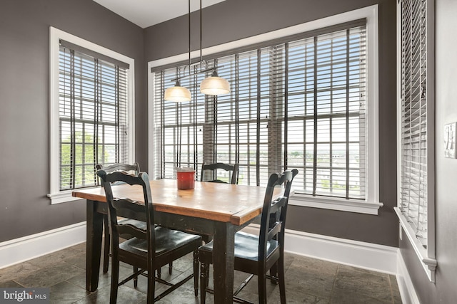 dining room featuring stone finish floor and baseboards