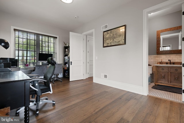 office space with dark wood-style flooring, visible vents, and baseboards