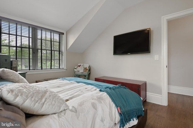 bedroom with vaulted ceiling, dark wood finished floors, and baseboards