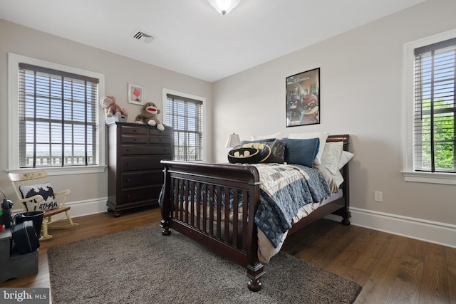 bedroom featuring baseboards, visible vents, and dark wood-type flooring