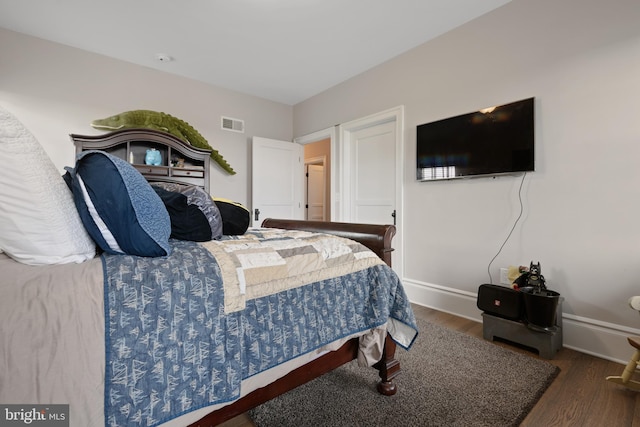 bedroom featuring dark wood-style floors, visible vents, and baseboards