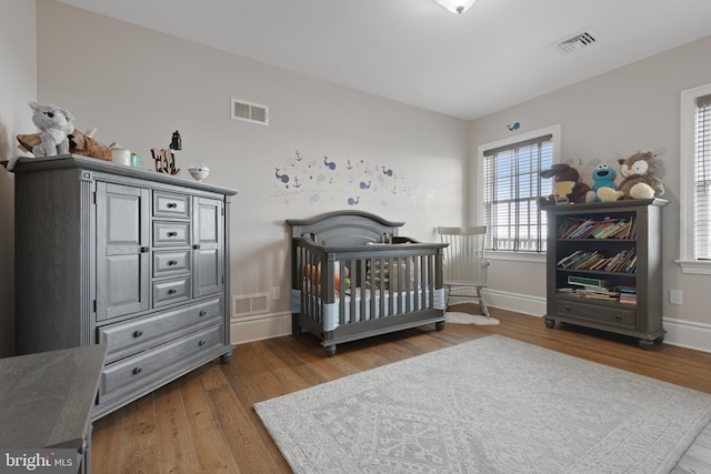 bedroom with wood finished floors and visible vents