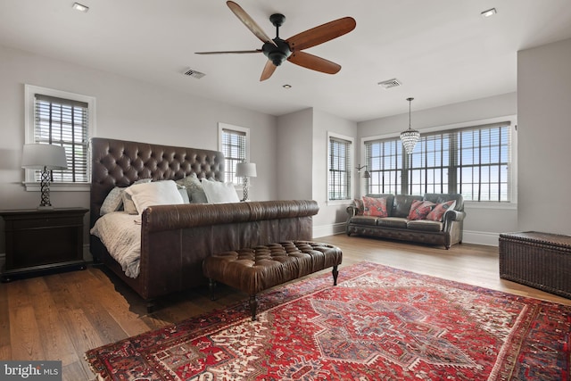 bedroom with multiple windows, visible vents, and wood finished floors