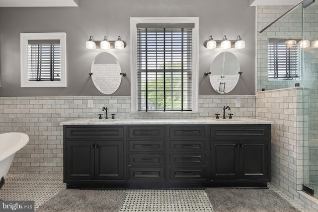 bathroom with a wealth of natural light, tile walls, and a sink