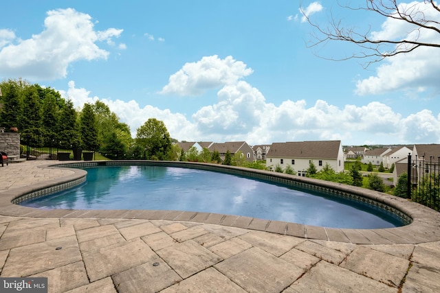 view of swimming pool featuring a fenced in pool, a residential view, a patio area, and fence